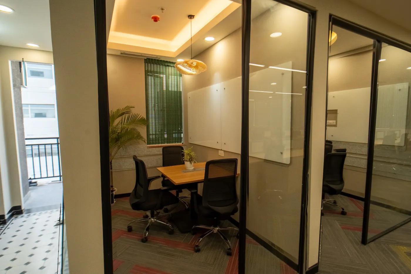 Row of glass-fronted private office cabins at an AIHP Sector 32 office, Gurgaon