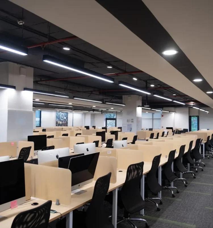 Open-plan workstation floor with rows of desks and computer monitors at AIHP Horizon