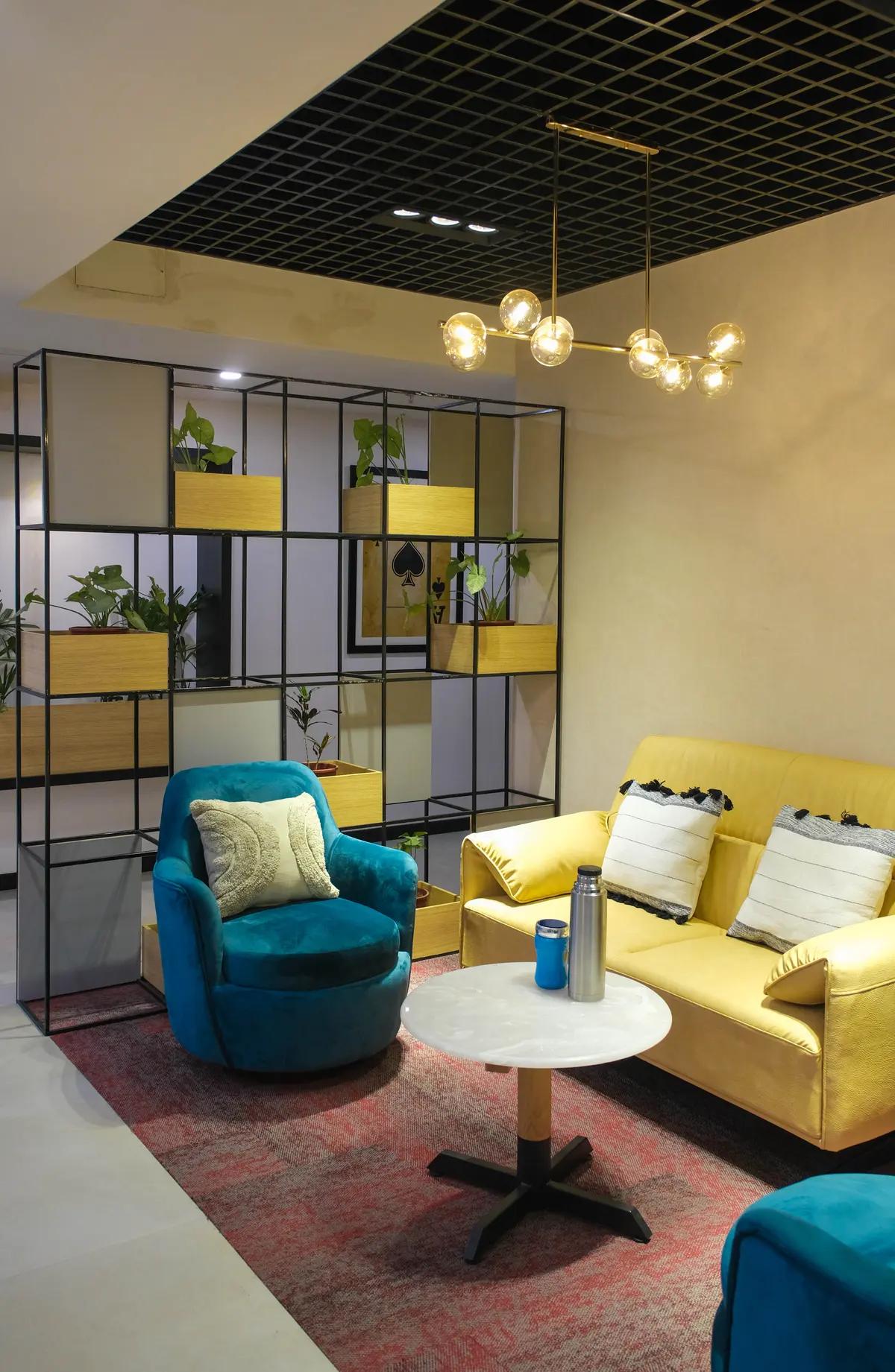 AIHP Milestone lounge and breakout area with sofa seating and a planter divider, Udyog Vihar Gurgaon