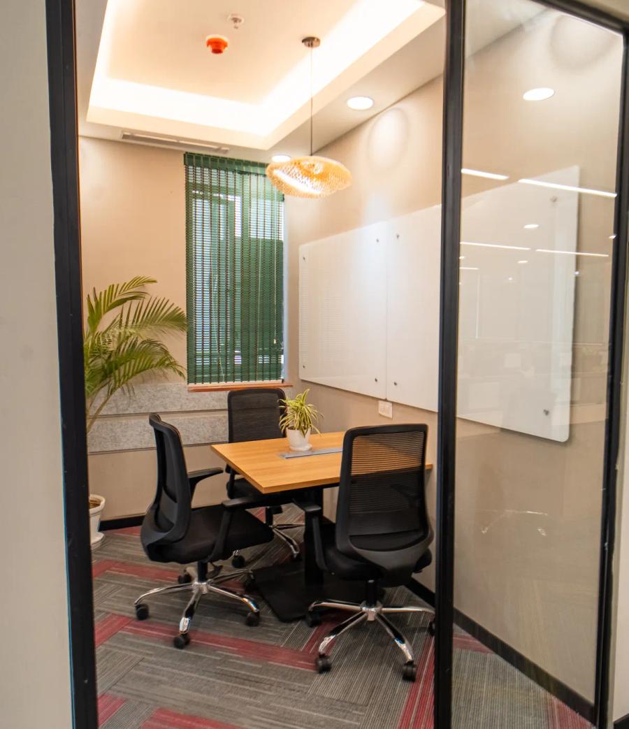 AIHP Atrium glass-walled private meeting room with whiteboard and city-view windows, Sector 32 Gurgaon