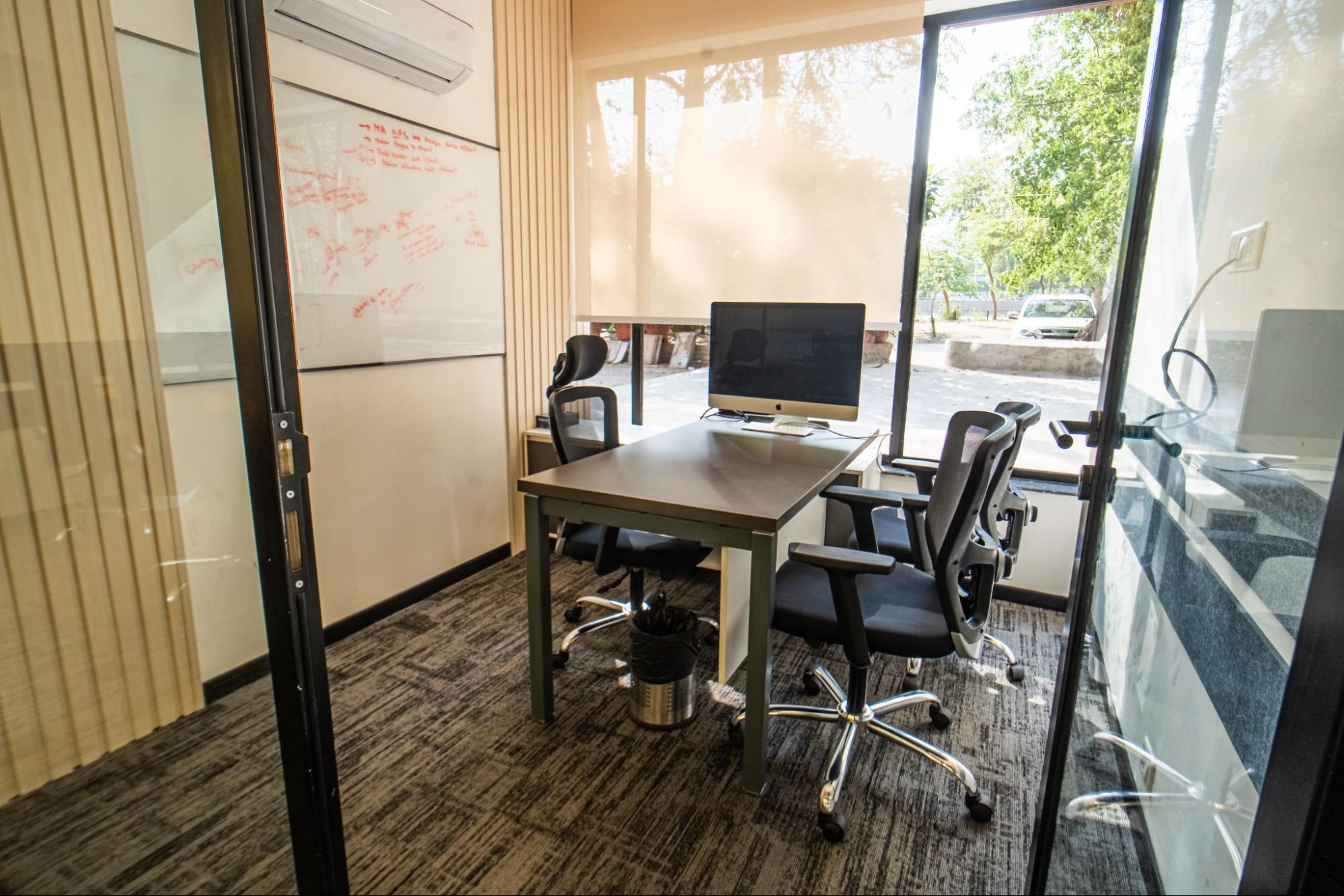 Glass-walled private cabin with desk, whiteboard and street-facing window, AIHP SCO 29B, Sector 32 Gurgaon