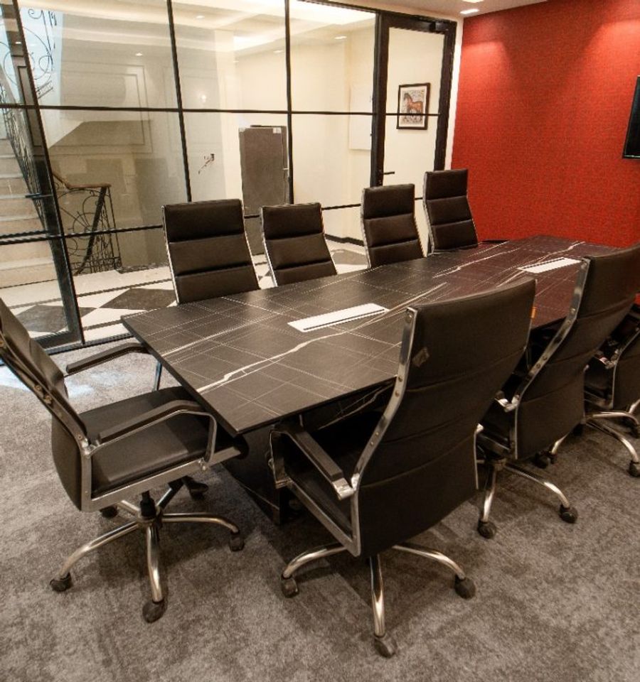 Boardroom with a long wood conference table and leather seating at AIHP Cyber Greens 2