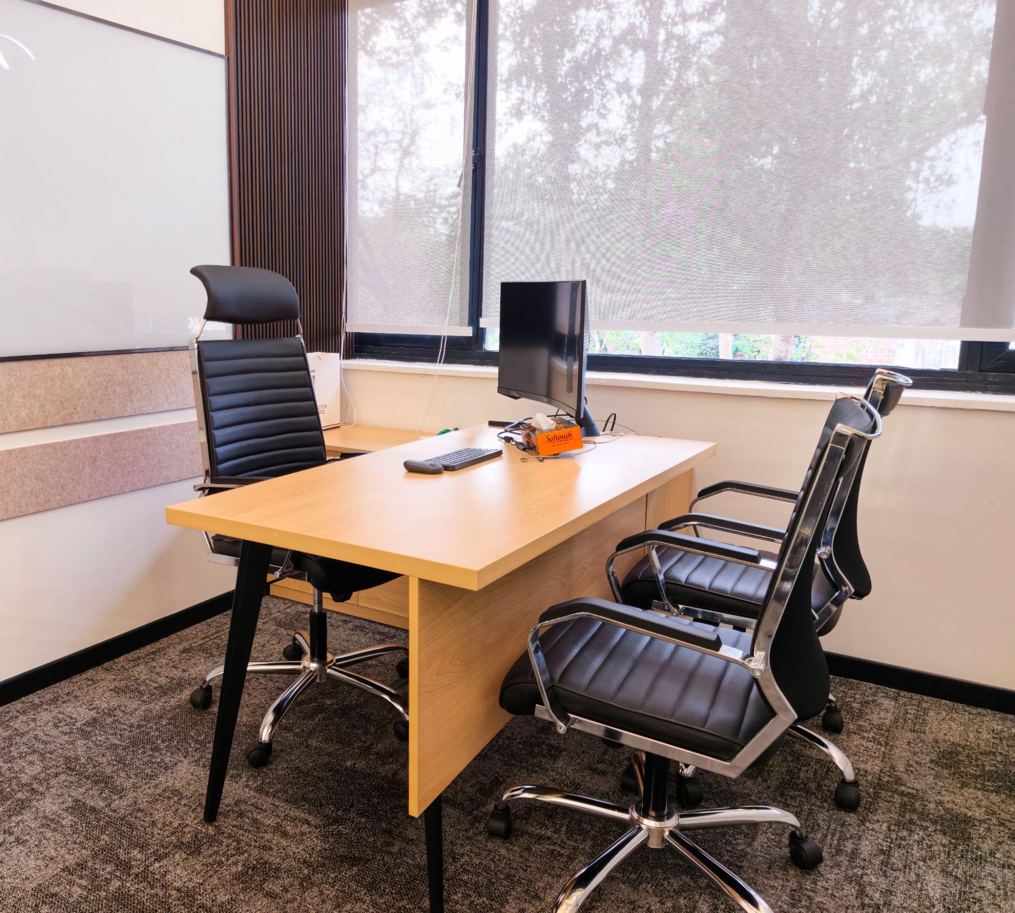 Private cabin with a wood desk, leather chairs, monitor and whiteboard by a tree-facing window, AIHP SCO 31, Sector 32 Gurgaon