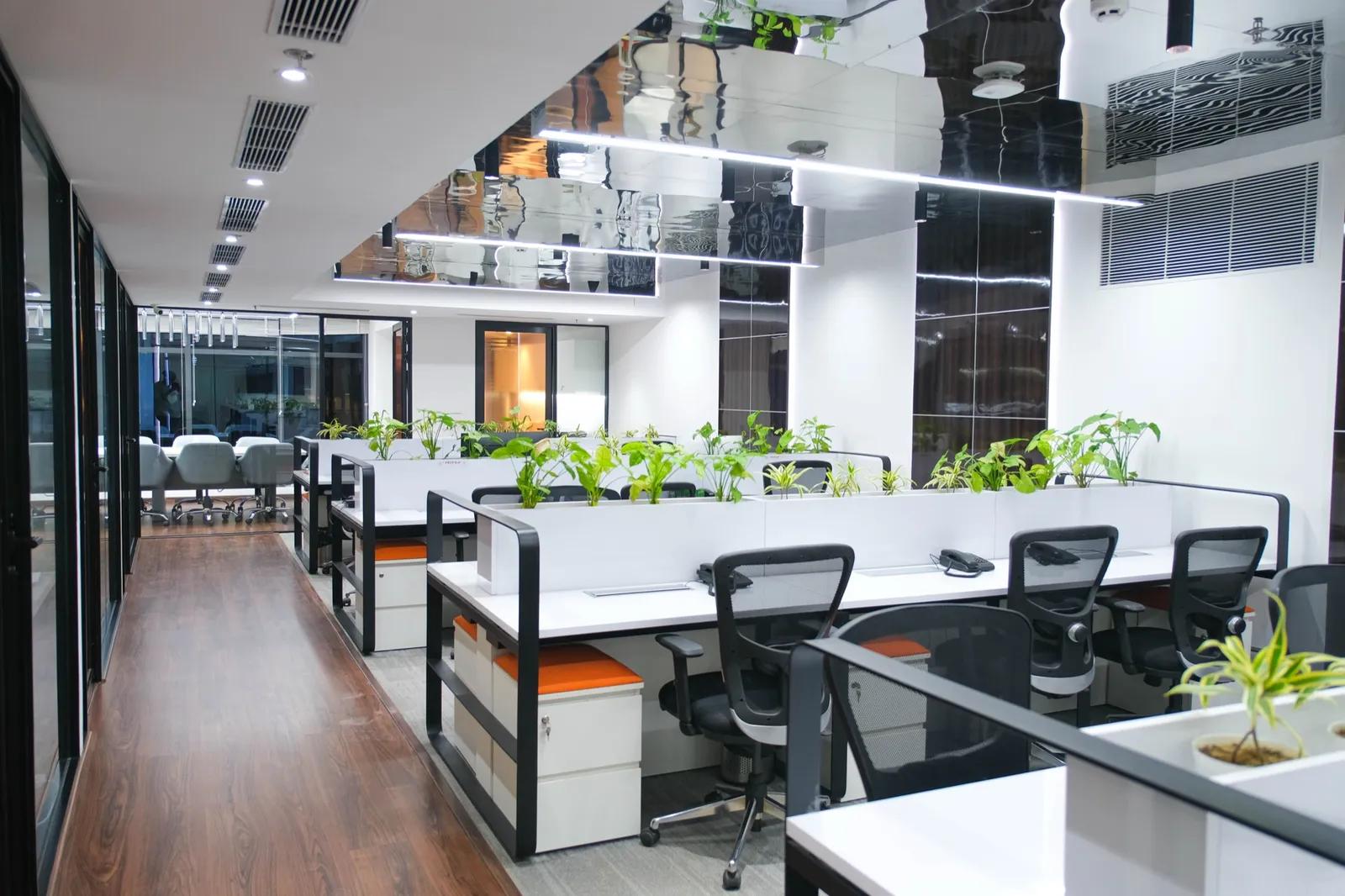 AIHP Milestone open-plan workstation bay with ergonomic seating and planters, Udyog Vihar Gurgaon