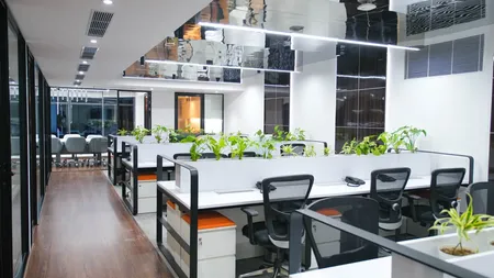 AIHP Milestone open-plan workstation bay with ergonomic seating and planters, Udyog Vihar Gurgaon