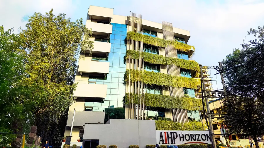 AIHP Horizon building facade with a green vertical plant wall and ground-floor signage