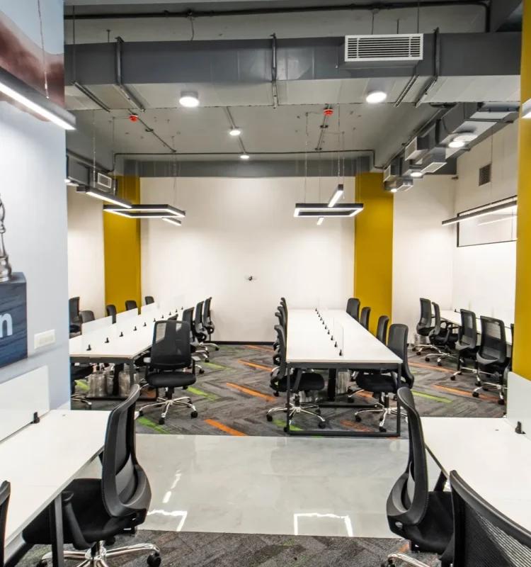 Meeting room at AIHP SCO 27 with long white tables, black chairs and yellow accent walls
