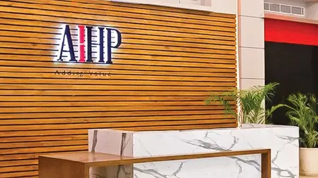AIHP reception with wood-slat signage wall, marble desk, and lime-green lounge seating