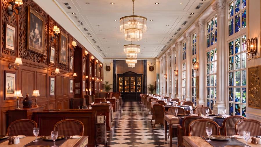 The Dining Lounge — timber-panelled dining room with stained-glass windows and crystal chandeliers at AIHP Imperial, Sector 32 Gurgaon