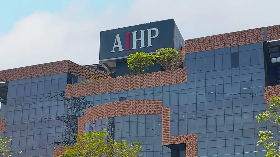 AIHP Milestone glass-and-brick office tower facade with rooftop branding, NH-8 Udyog Vihar Phase V, Gurgaon