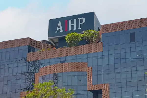 AIHP Milestone glass-and-brick office tower facade with rooftop branding, NH-8 Udyog Vihar Phase V, Gurgaon