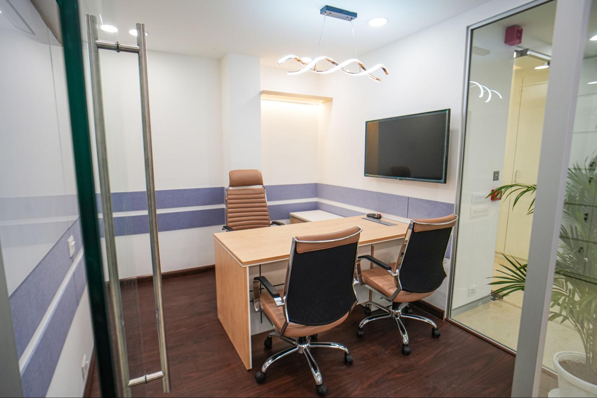 Private manager cabin with desk and wall-mounted screen at AIHP 507-508