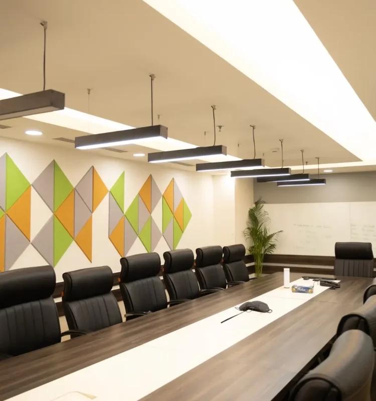 Conference room with dark wood table, leather chairs, triangular accent wall, whiteboard and planter, AIHP Horizon, Udyog Vihar Gurgaon