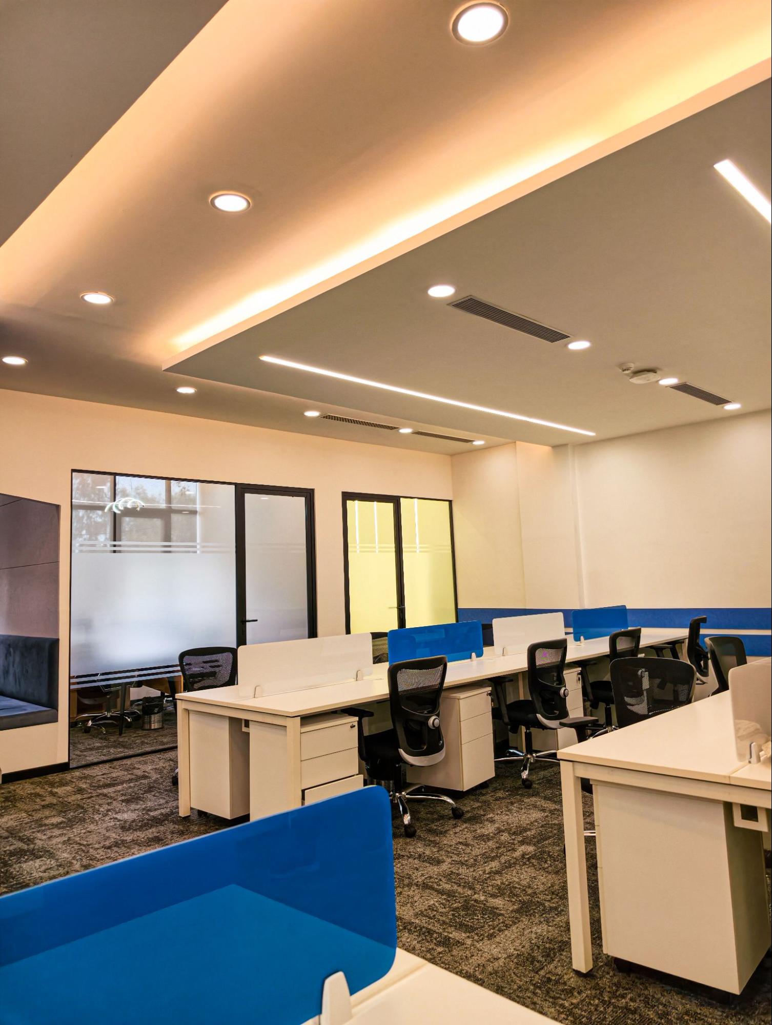 Open-plan workstations with blue desk screens, mesh chairs and glass cabins, AIHP SCO 31, Sector 32 Gurgaon