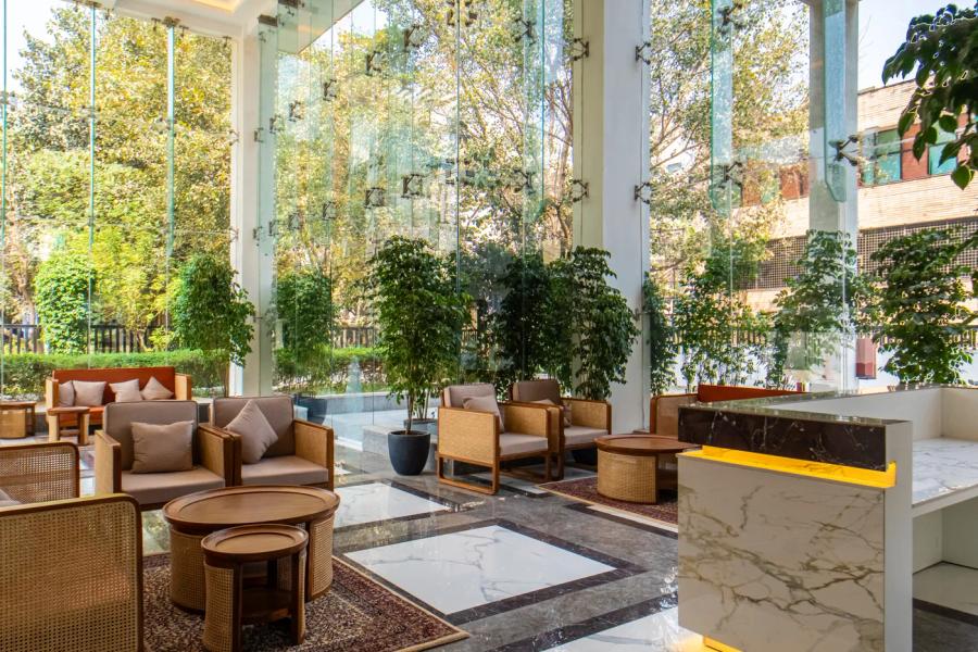 Light-filled lounge with floor-to-ceiling glass at an AIHP Sector 32 office, Gurgaon
