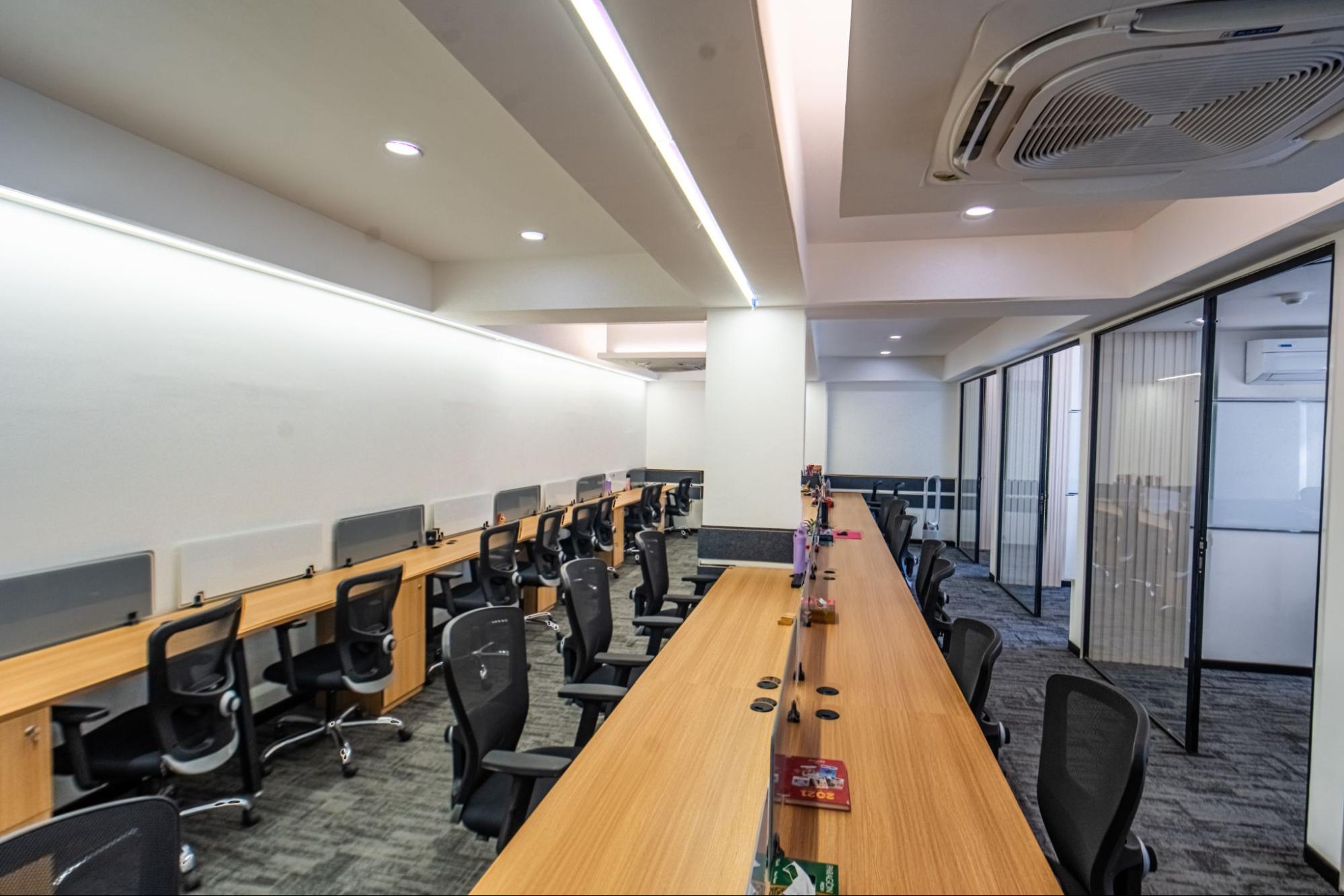 Open-plan bench workstations with mesh chairs and glass cabins, AIHP SCO 29B, Sector 32 Gurgaon