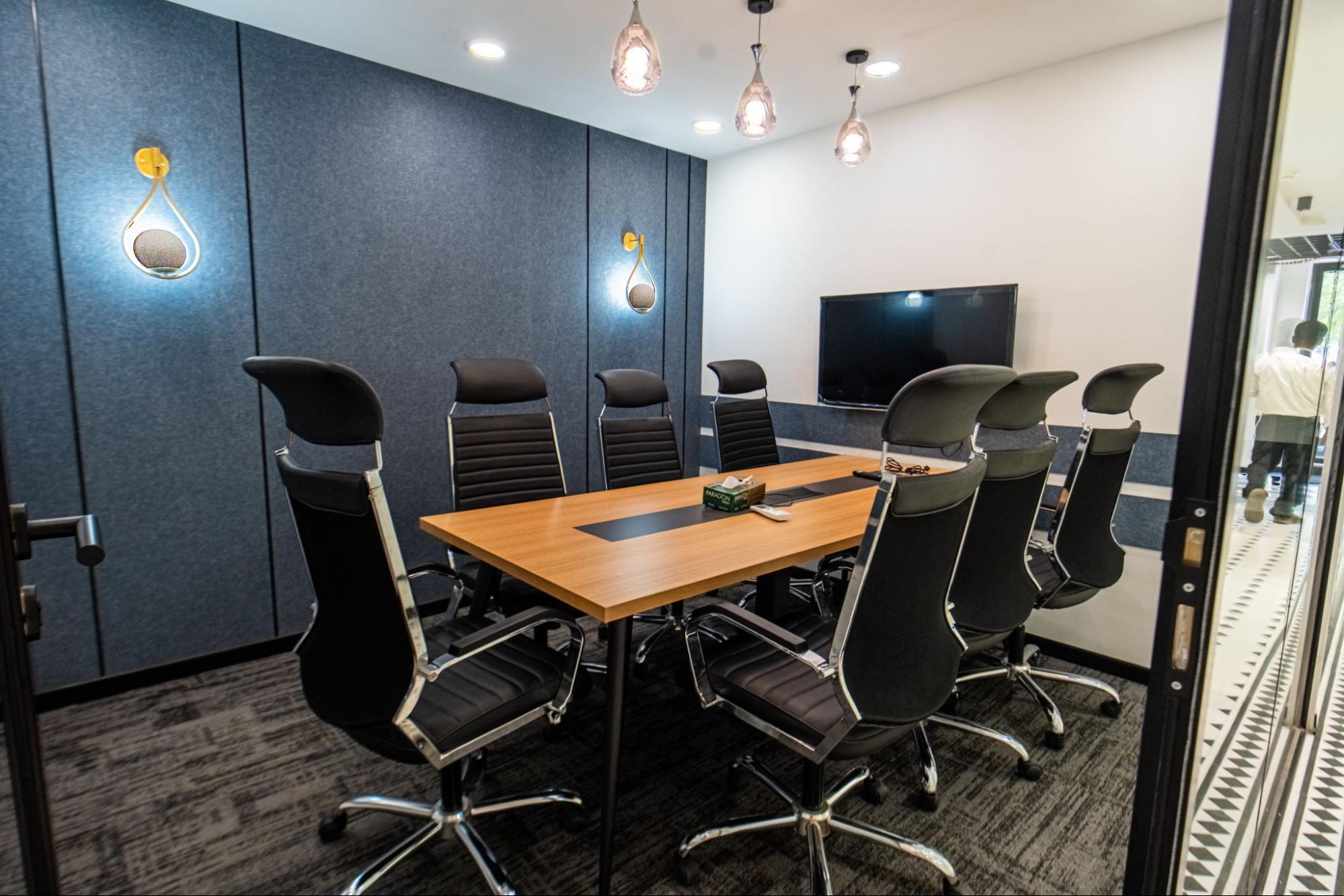 Meeting room with a wood table, navy panelled walls and glass pendant lights, AIHP SCO 29B, Sector 32 Gurgaon