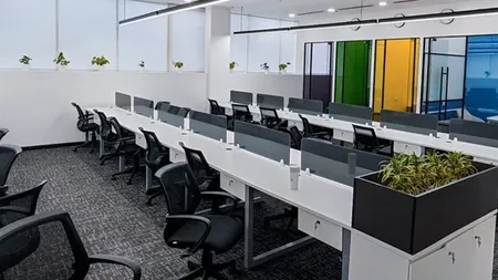 Open-plan desks beside glass partition doors with colored glass panels