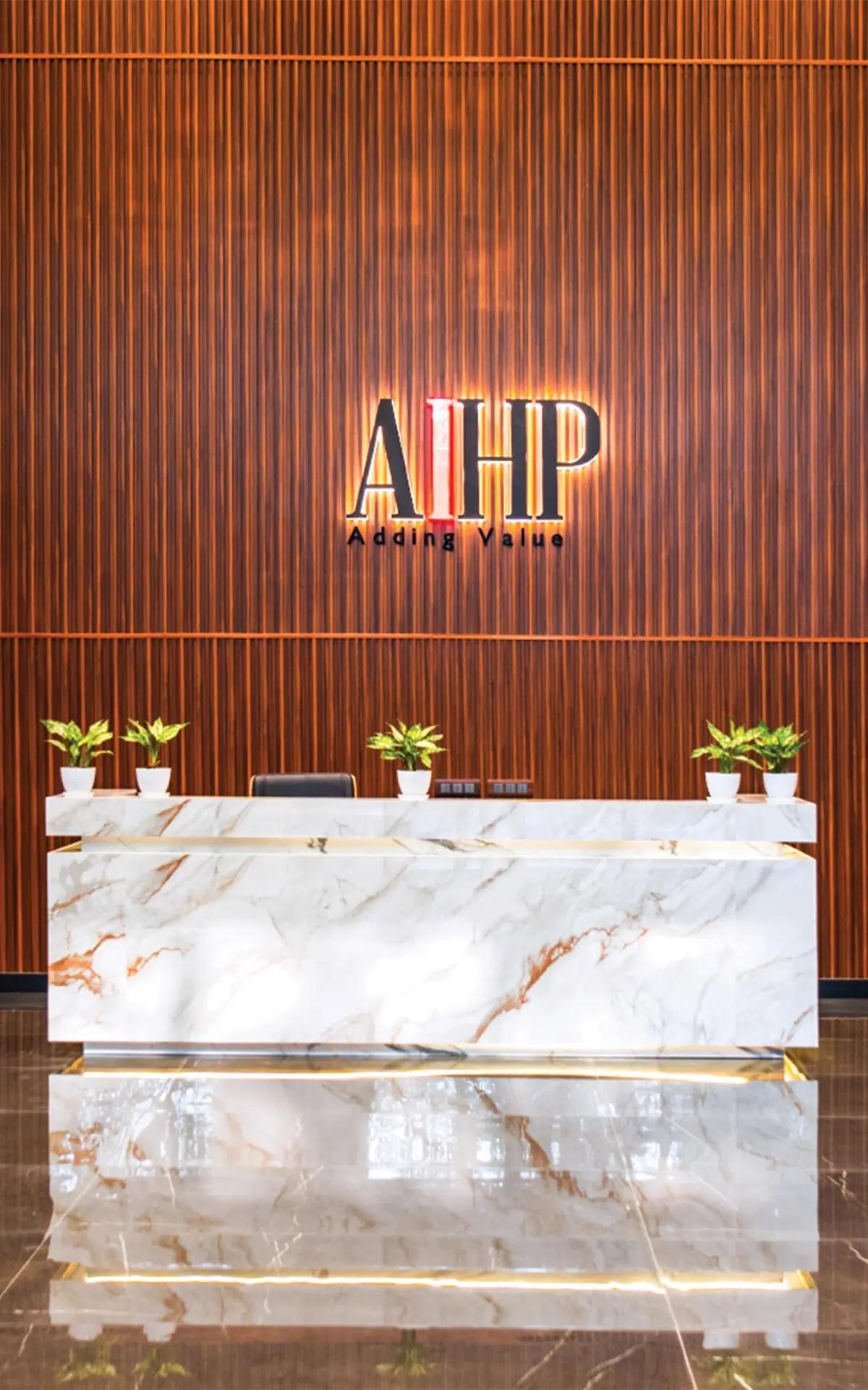 AIHP Millennium reception with marble desk and backlit branding, Udyog Vihar Gurgaon