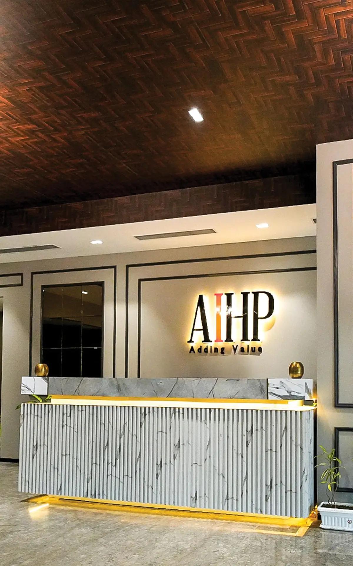 AIHP Cyber Greens reception with woven wood ceiling and illuminated AIHP signage