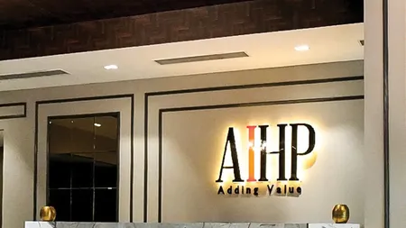 AIHP Cyber Greens reception with woven wood ceiling and illuminated AIHP signage