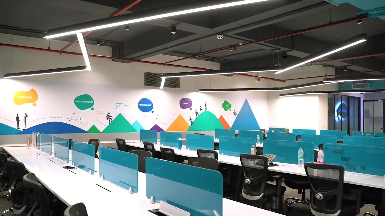 AIHP Milestone open-plan workspace with a motivational wall mural and linear lighting, Udyog Vihar Gurgaon