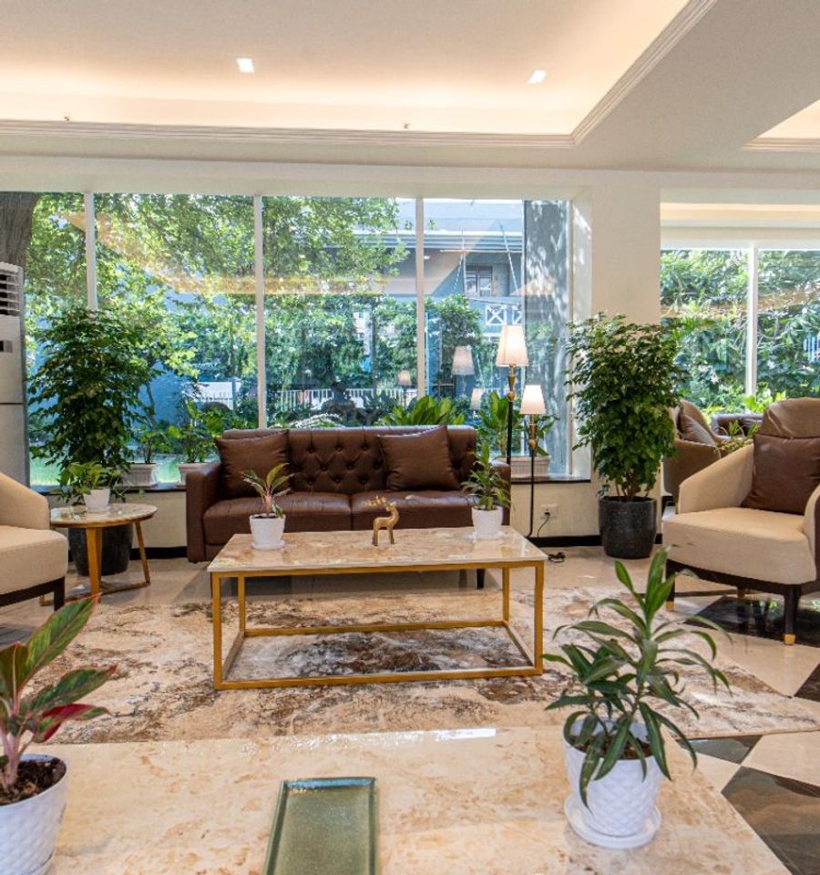 Lounge seating beside floor-to-ceiling windows overlooking greenery at AIHP Cyber Greens 2