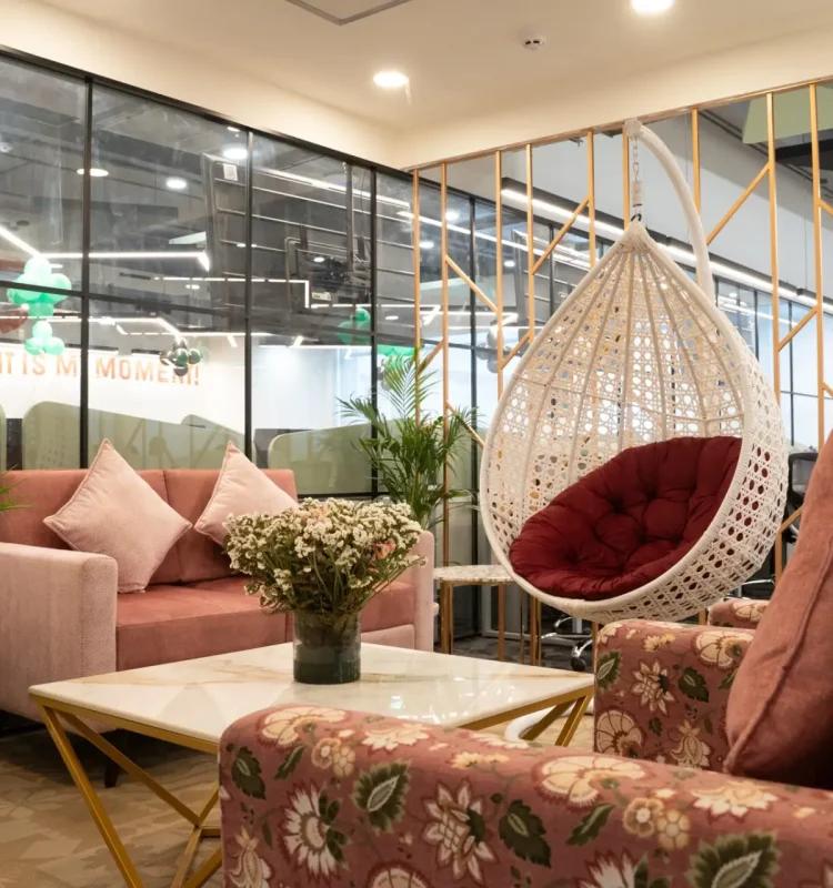 White rattan swing chair beside blush sofas and floral armchairs, AIHP Executive Center, Sector 32 Gurgaon