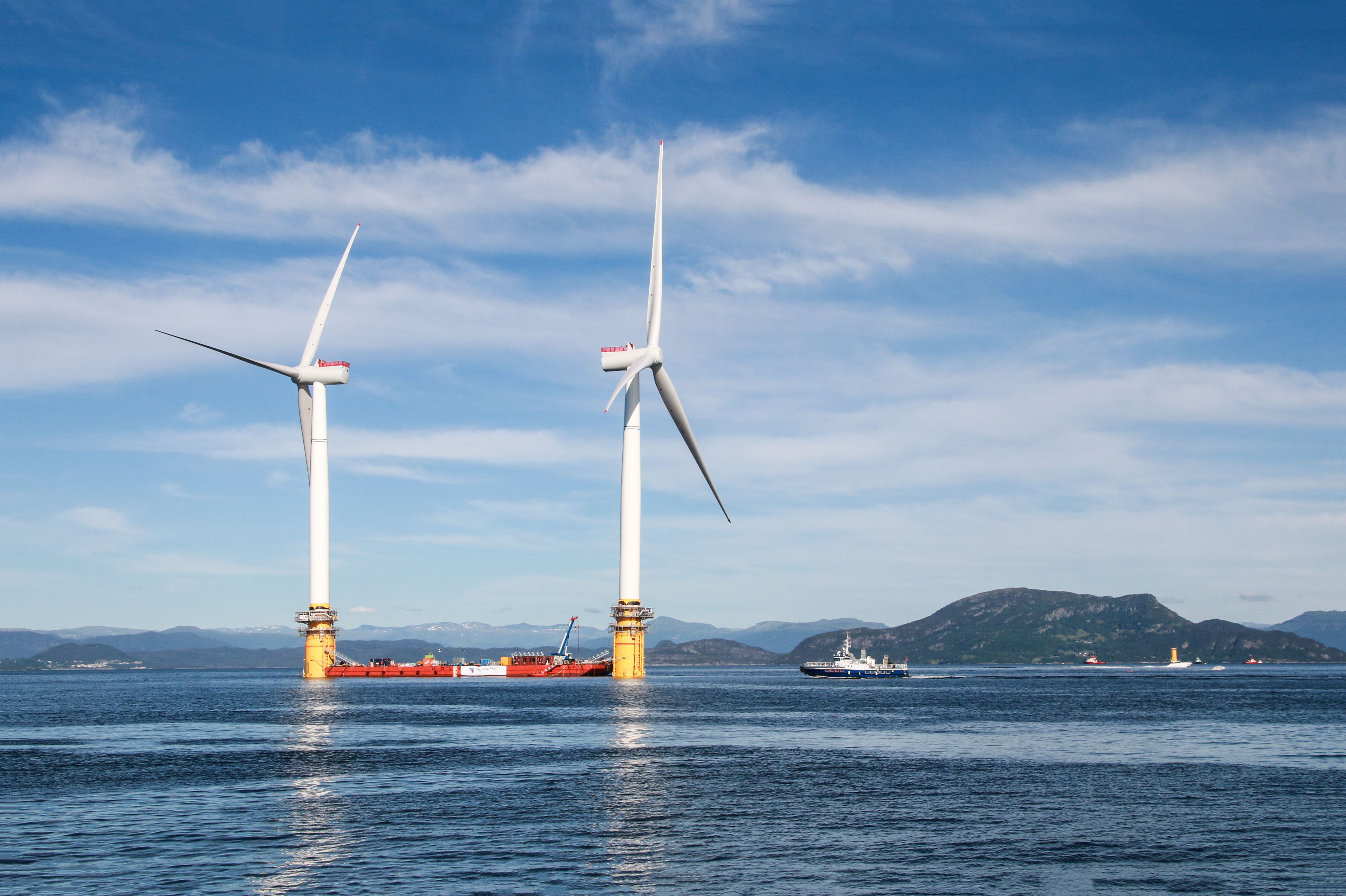 a picture of two floating wind turbines being prepared to sail