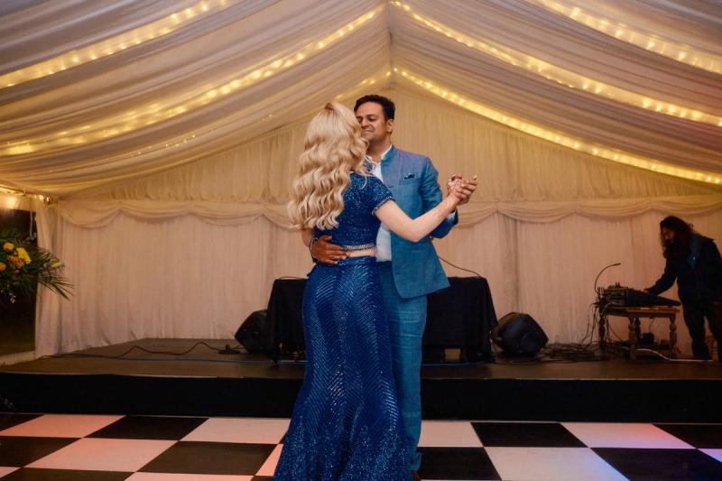 Bride and groom dancing as guests watch at the wedding reception