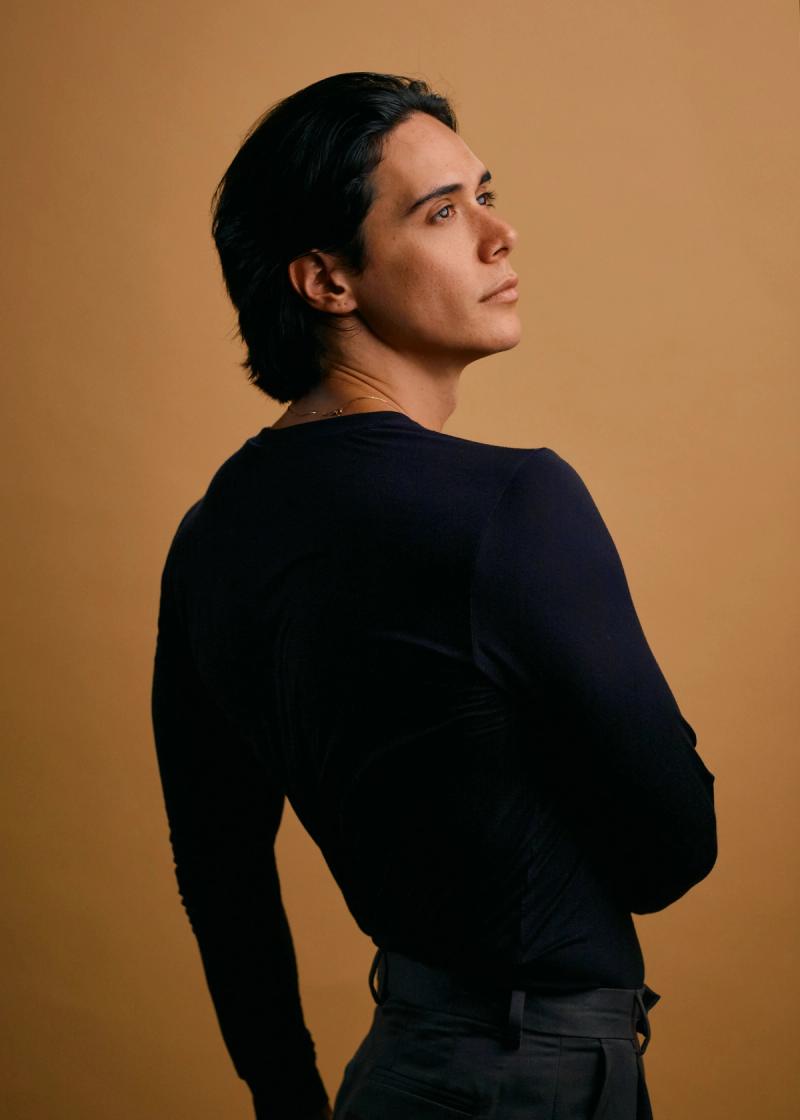 Male fashion portrait with long hair and direct gaze in a studio setup