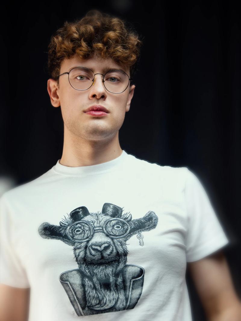 A man with glasses wearing a white shirt.