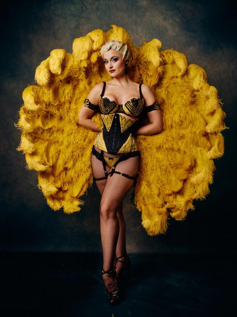 Full-length studio portrait of a model in an avant-garde gold dress