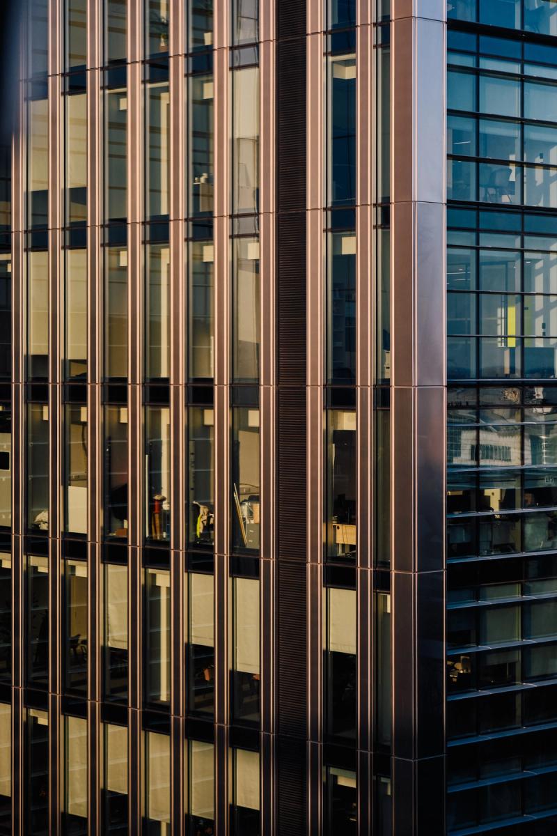 Modern commercial office tower facade with rose gold vertical mullions and floor-to-ceiling tinted glass curtain wall, City of London