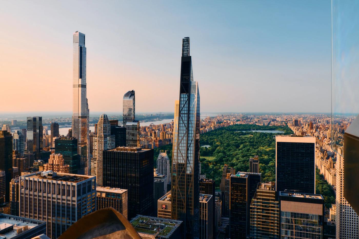 The image captures a panoramic view of New York City's skyline, featuring the Empire State Building, the World Trade Center, and the One World Trade C