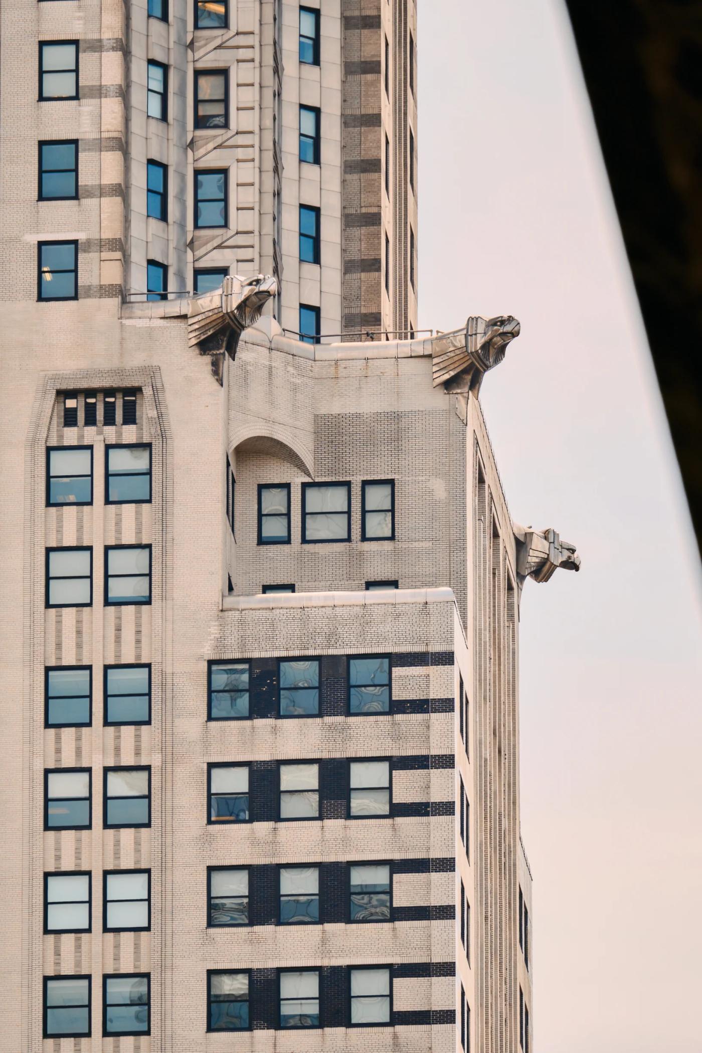 A tall, white building with multiple windows and a clock tower on the side.