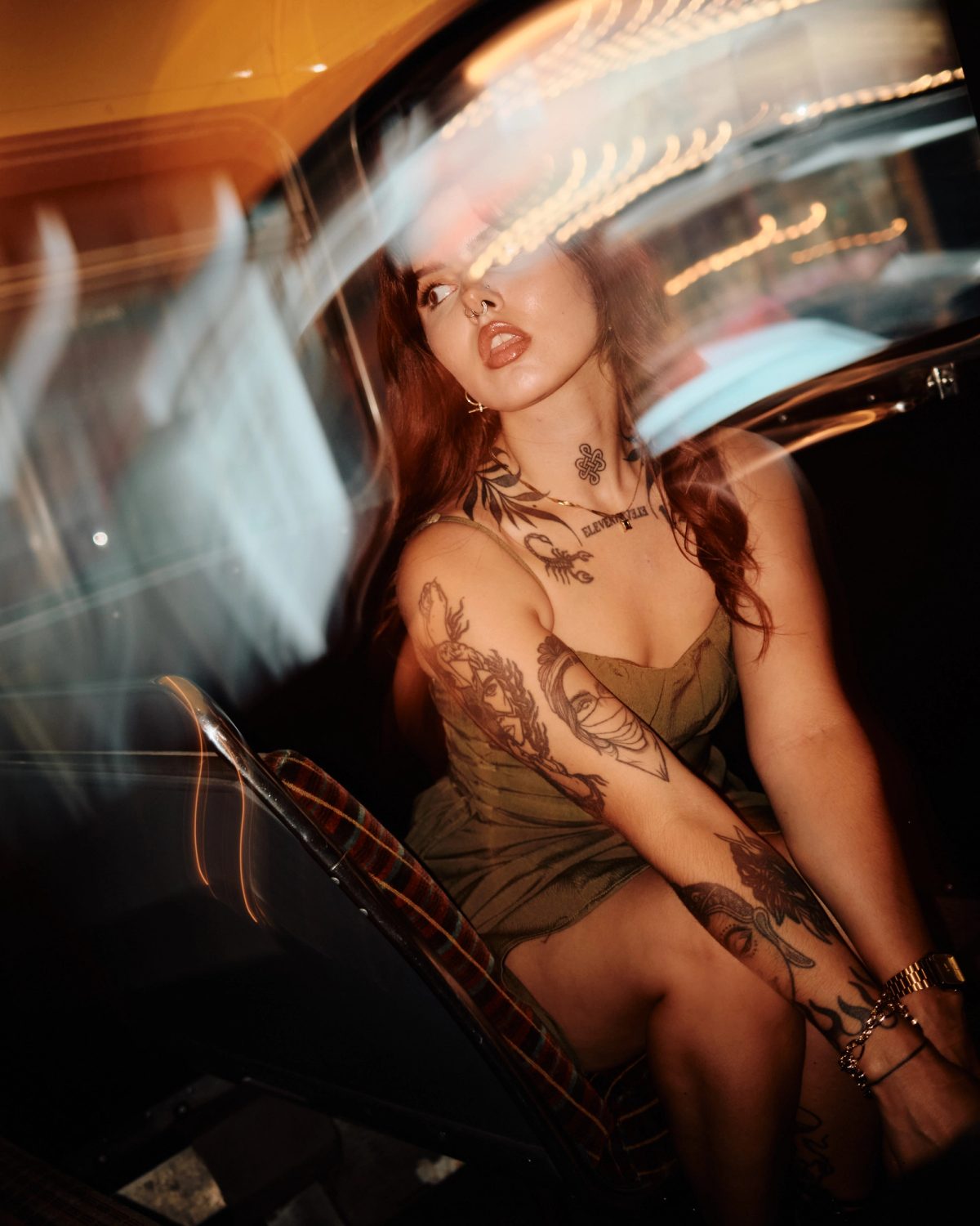 Motion-blur portrait of a tattooed woman seated in a retro diner booth
