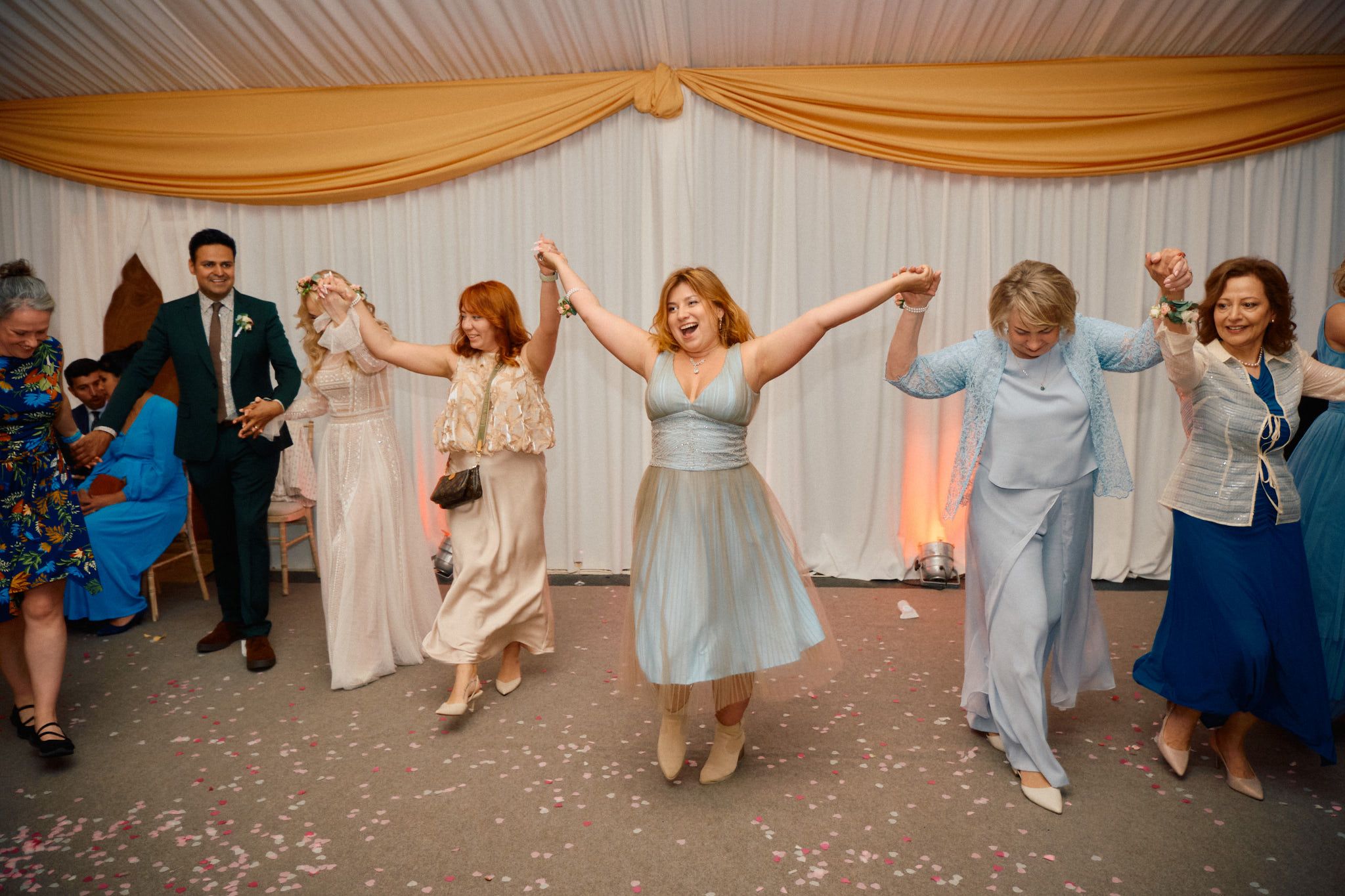 Wedding party with people dancing, bride, groom and guests happy