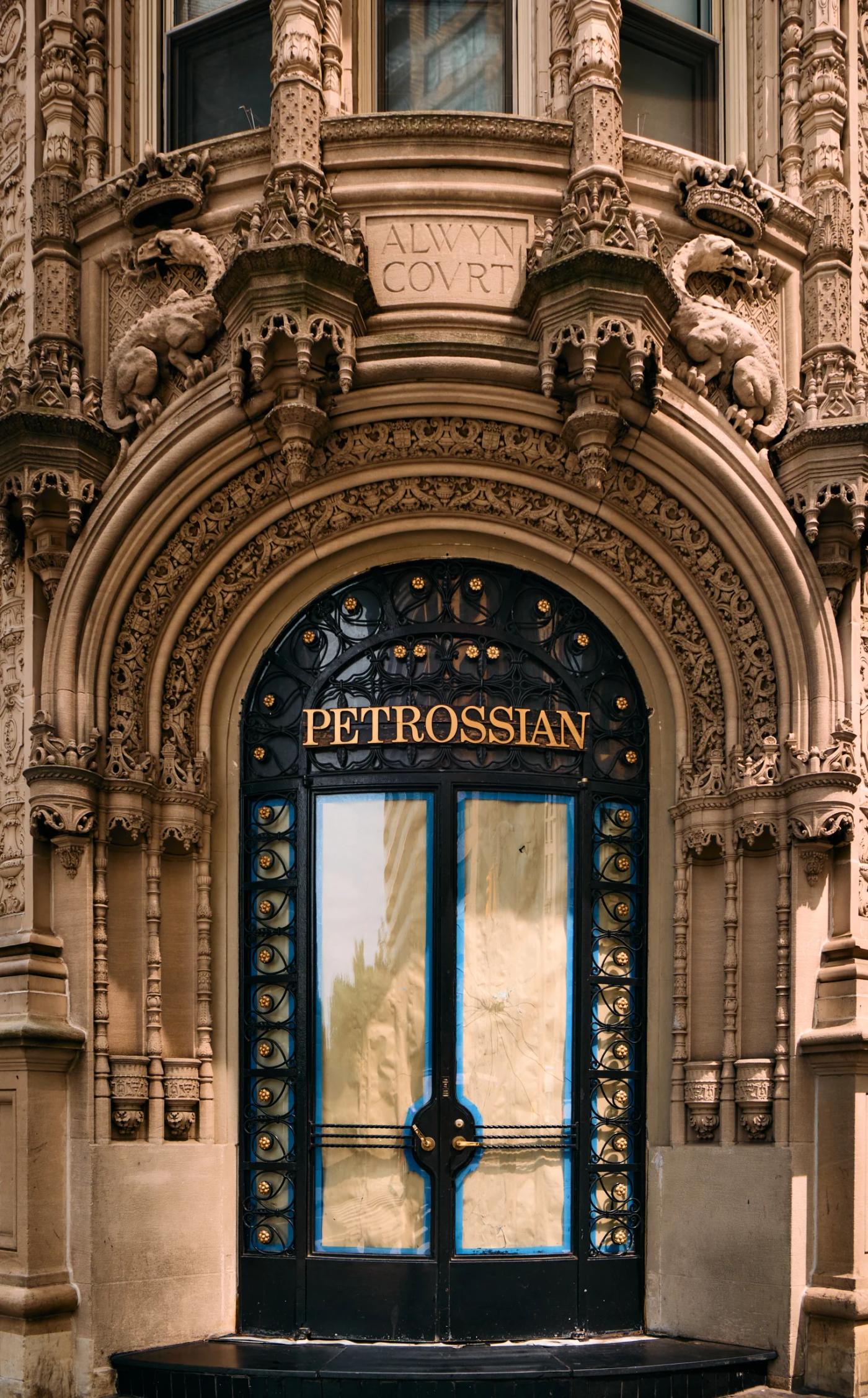 The image features a grand, ornate building with a large, ornate door adorned with intricate carvings and a gold "Theater" sign. The building is flank