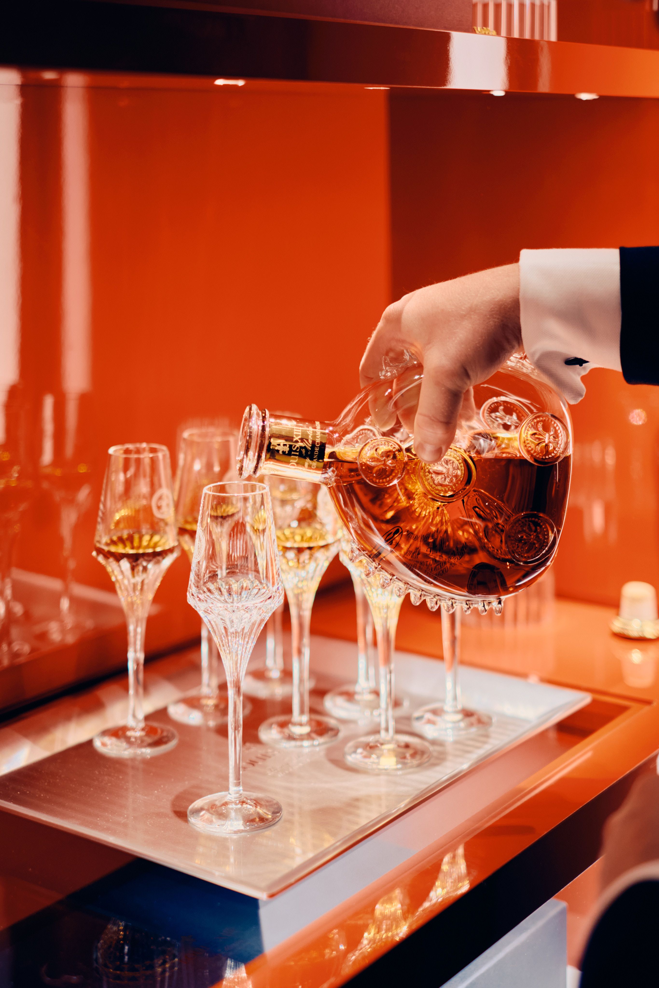 Louis XIII cognac decanter poured into crystal glasses 