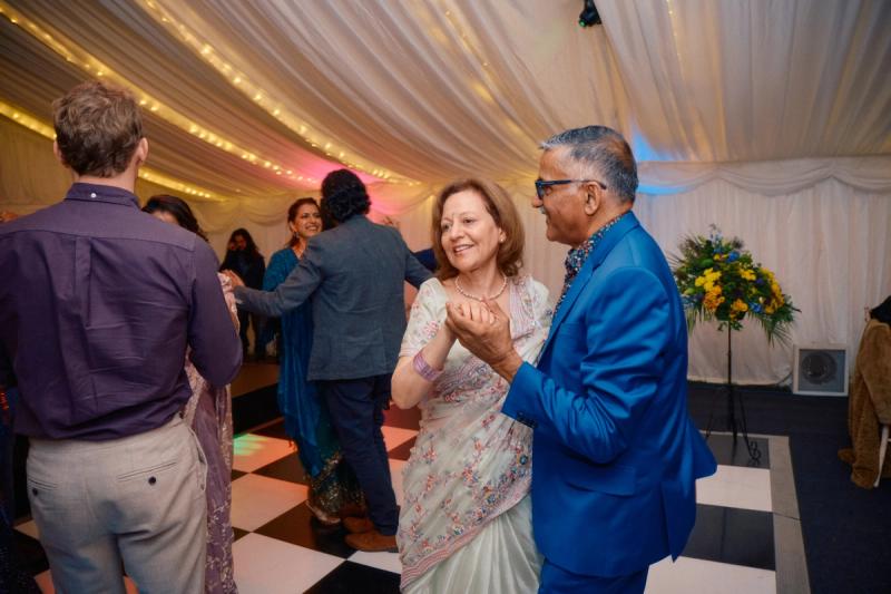 Wedding guests dancing energetically on the reception dance floor