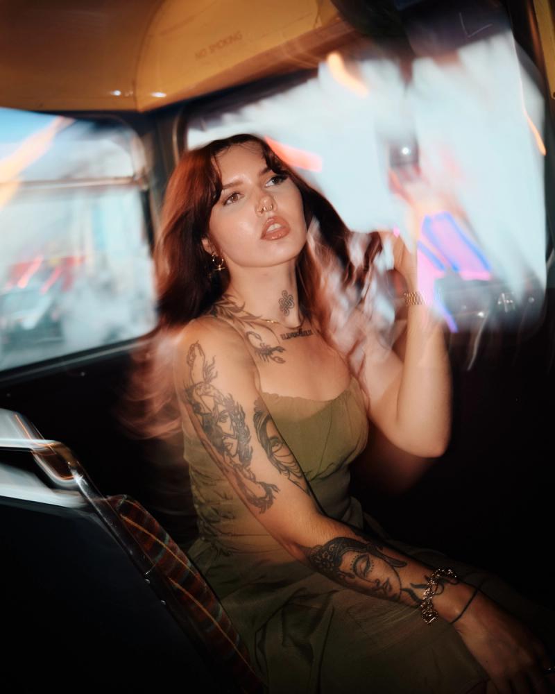 Creative motion portrait of a tattooed woman in warm nightlife lighting
