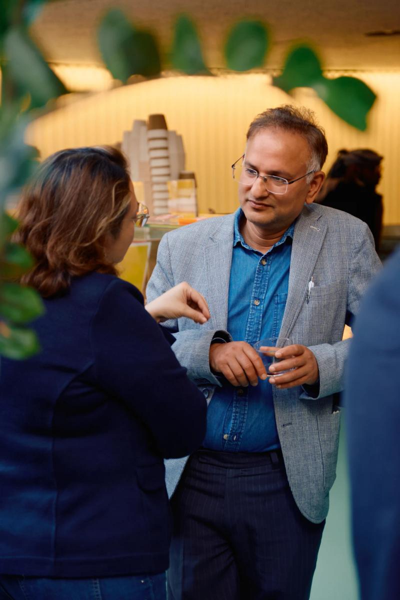 Two people in a room, one wearing a blue shirt and the other a black shirt.