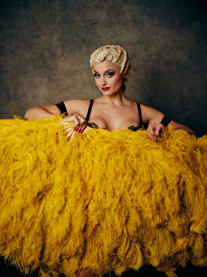 Editorial full-body portrait of a model in a gold statement gown and heels