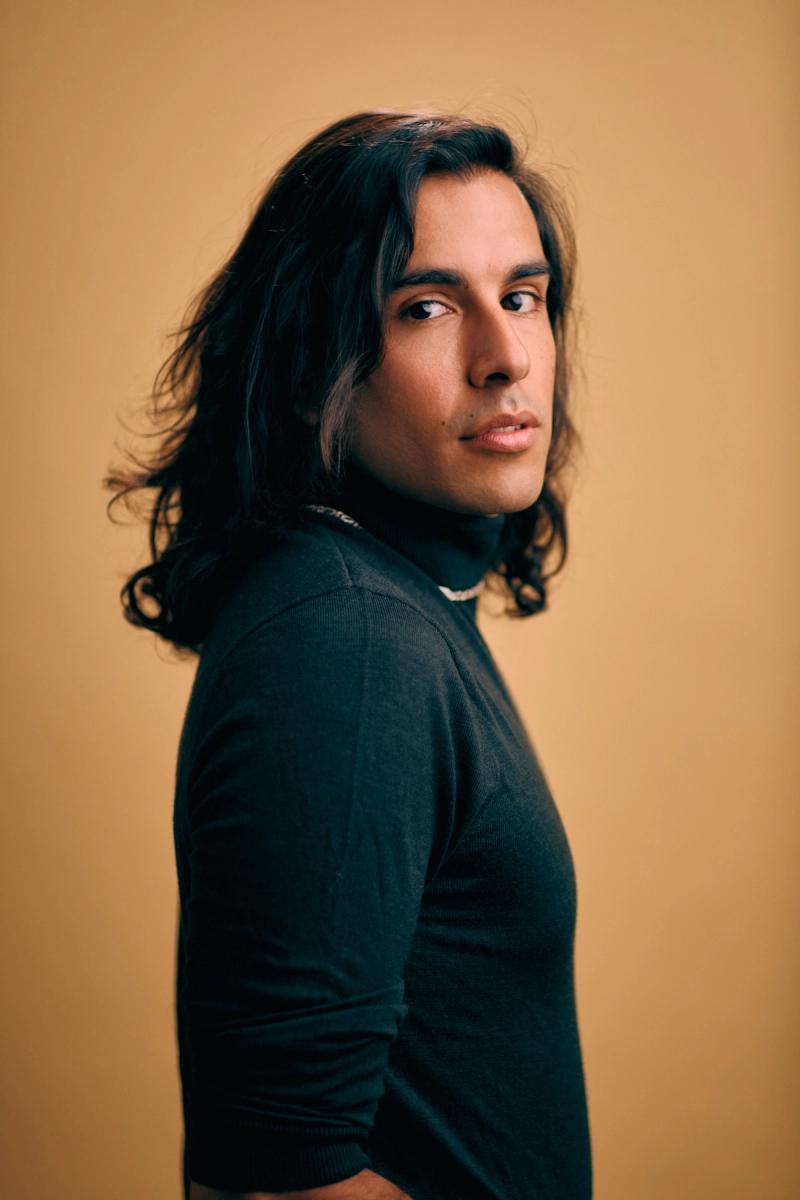 Studio portrait of a young man in black with cinematic lighting