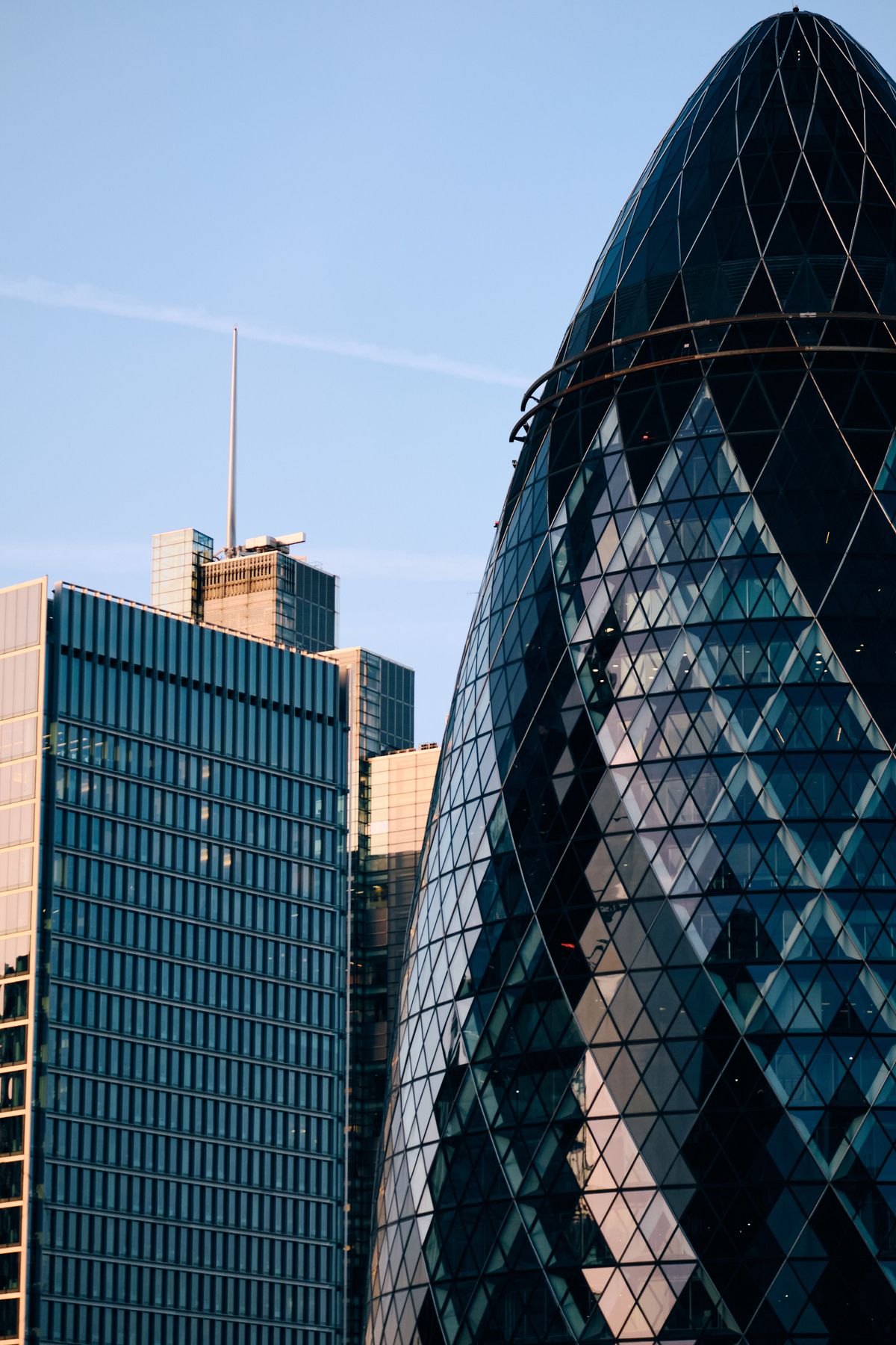 Contemporary high-rise office building corner with terracotta metal louvers and blue glass curtain wall with coloured horizontal striping, City of London