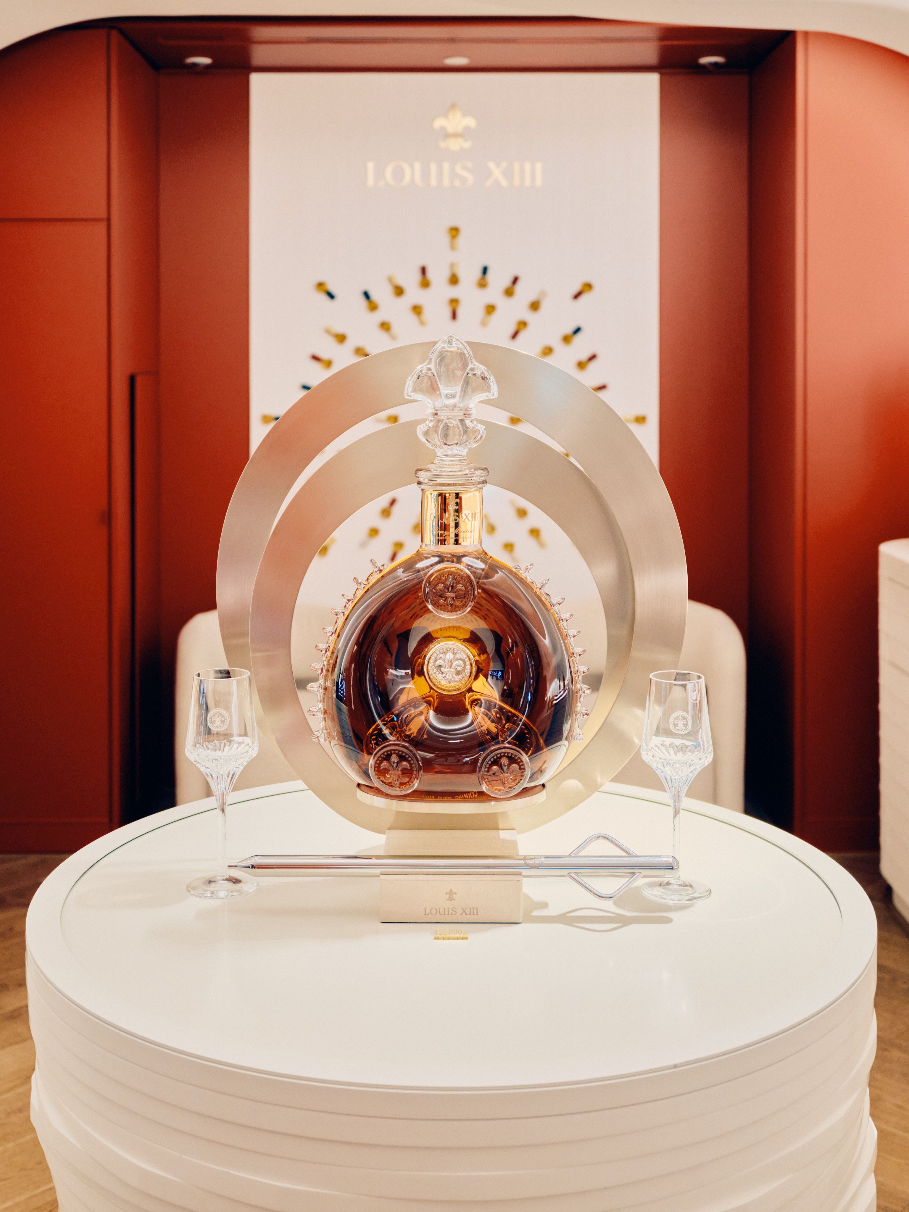 Louis XIII luxury cognac signage in store with decanter and soft lighting in a modern interior design environment