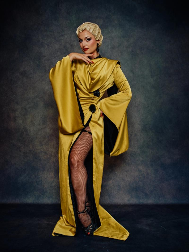 Fashion portrait of a model in a bold gold couture dress with strong lines