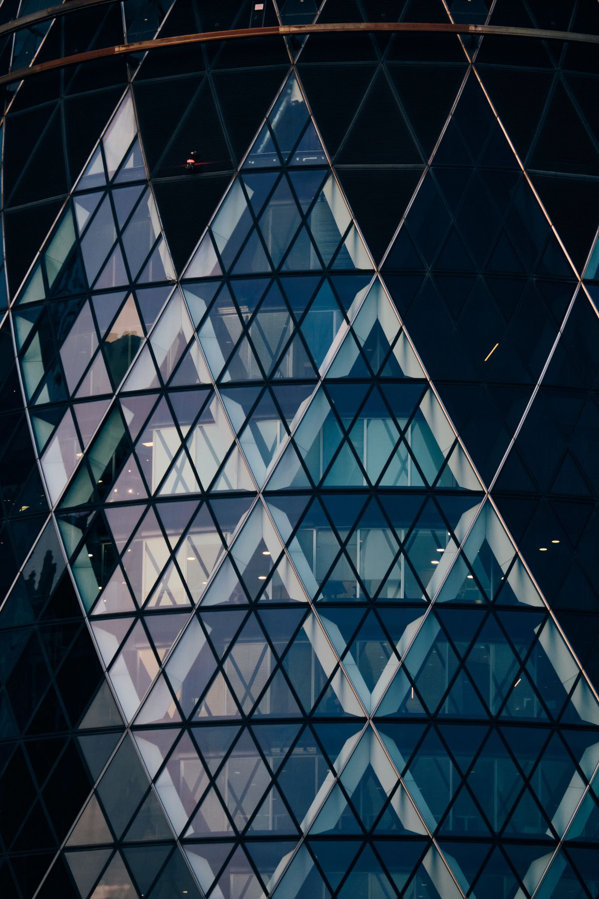The Gherkin 30 St Mary Axe iconic curved glass tower with diagonal lattice framework beside modern office buildings, City of London financial district