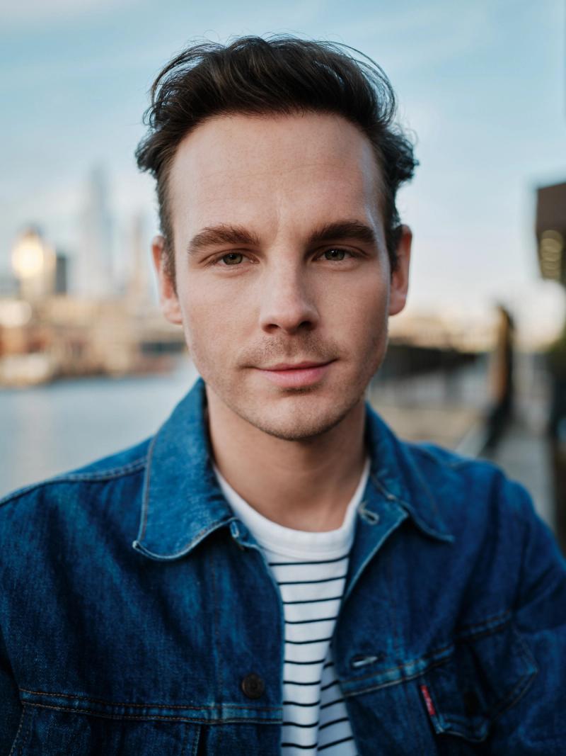 Natural light headshot of a man in a denim jacket outdoors